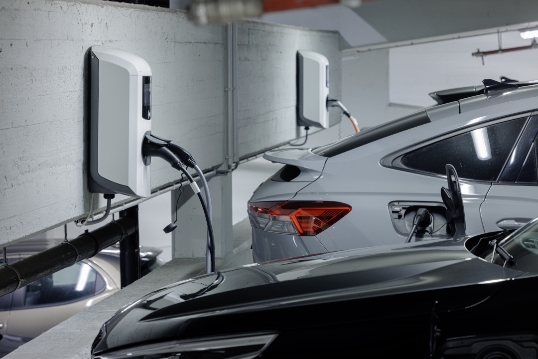 Een rij auto's die gekoppeld staan aan laadpalen in een parkeergarage